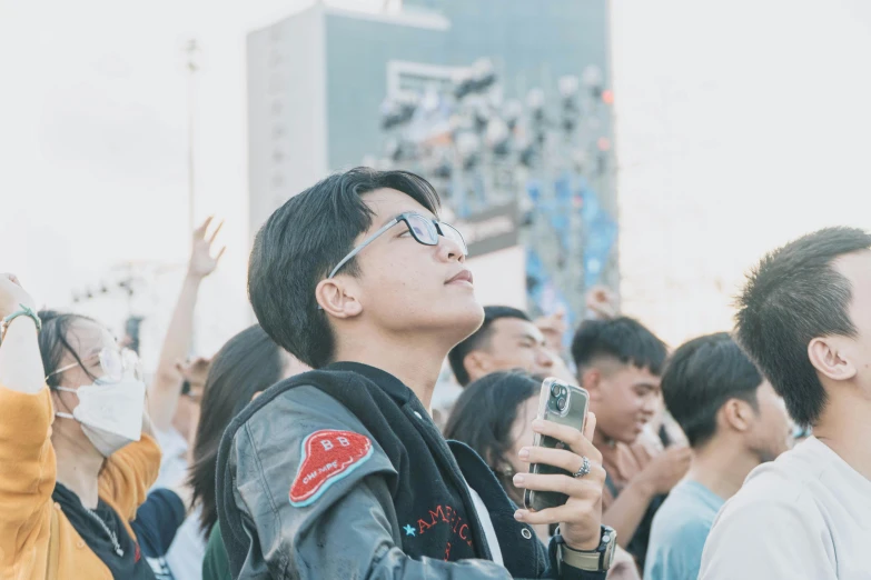 man using cell phone while standing in crowd