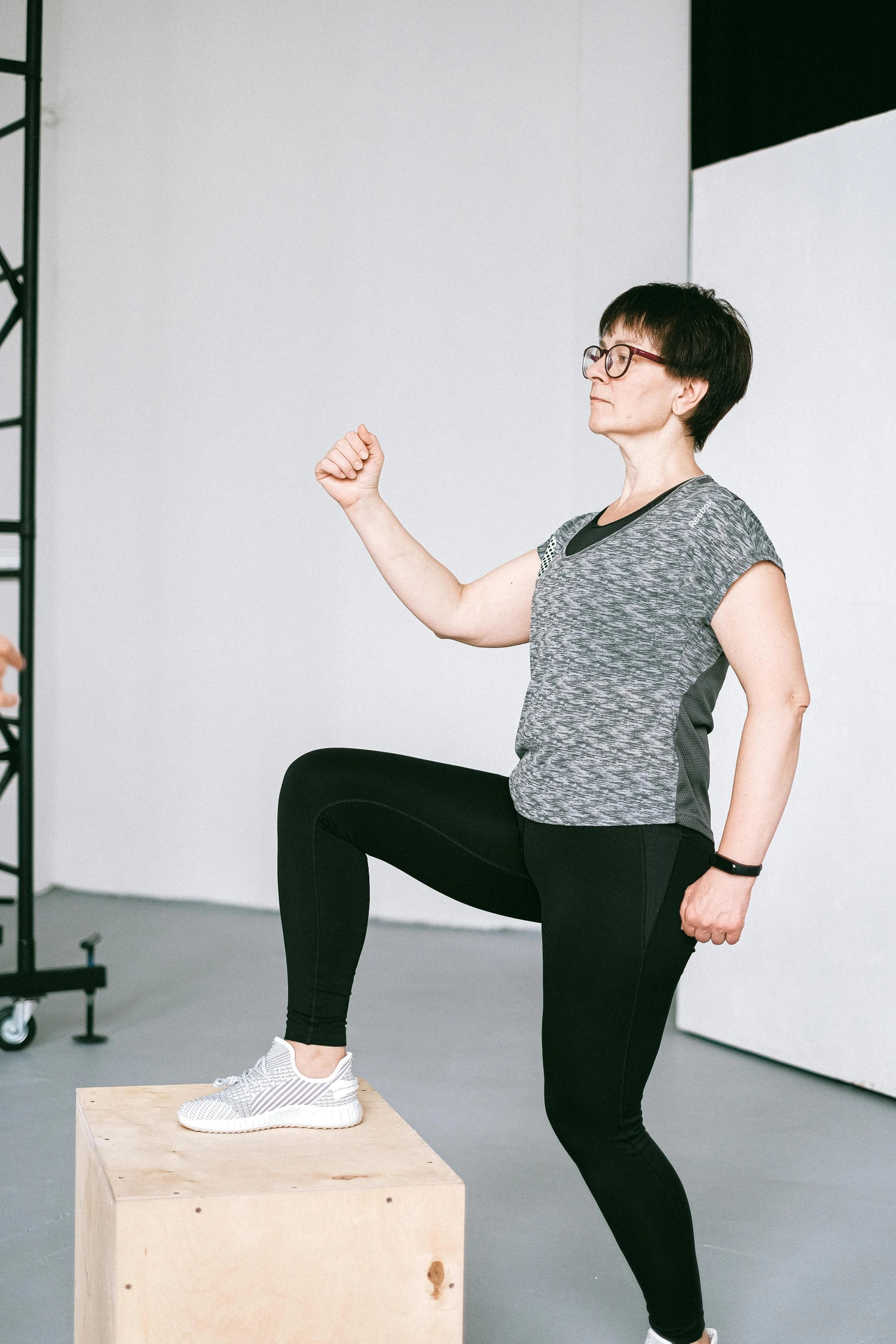 a woman doing a standing yoga pose on a platform