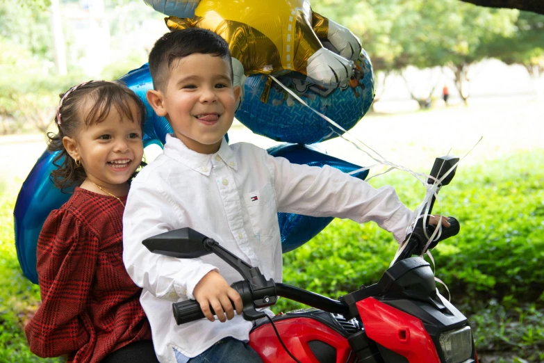 the two young children are posing on the scooter