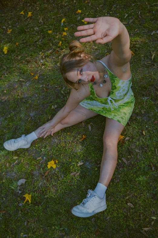 a beautiful woman laying in the grass with her arms up