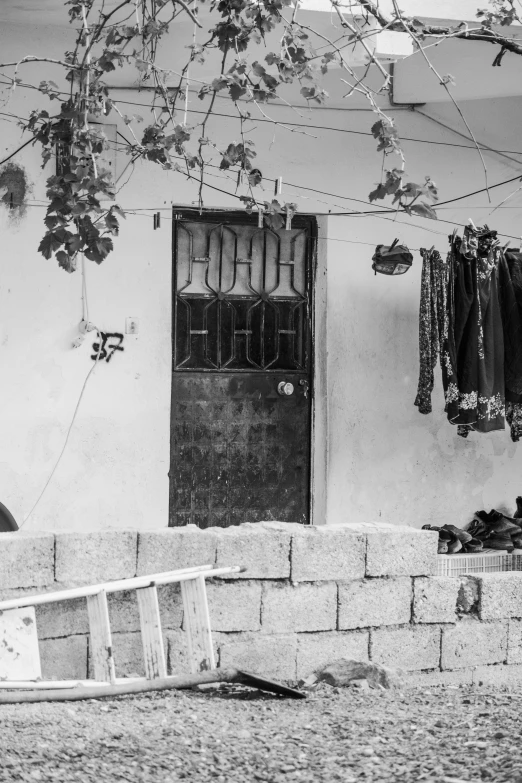 black and white pograph of a door, clothes line, boat and door to another building