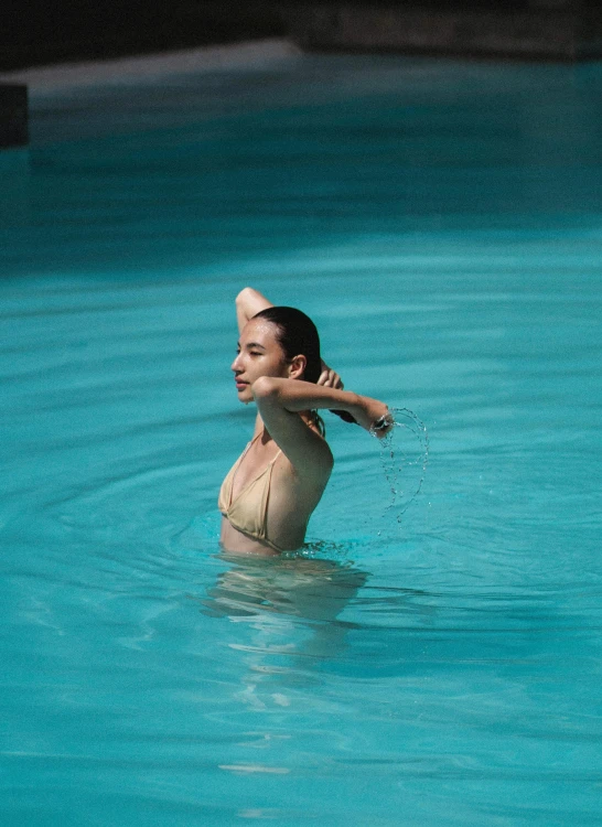 a woman swimming in a blue pool of water