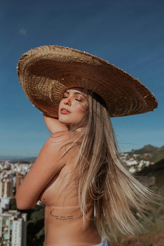 a girl posing in a sombrero with her head up