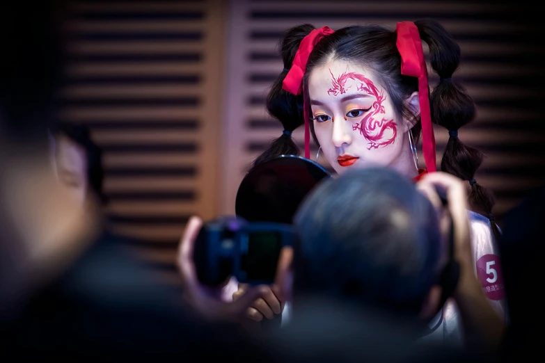 a woman with white makeup holding a mirror