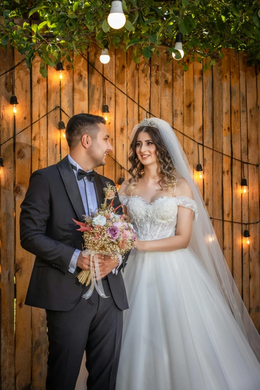 a woman in a white dress is next to a man in a grey suit