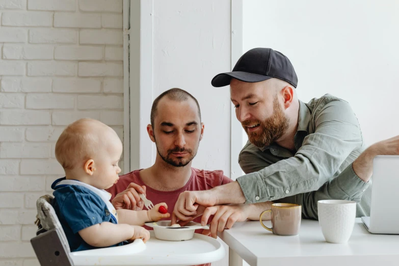 a man is helping a little boy who has cereal