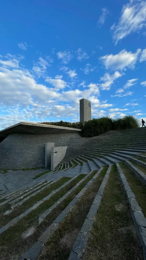 two people walk up an ancient stairs, with stone architecture in the background