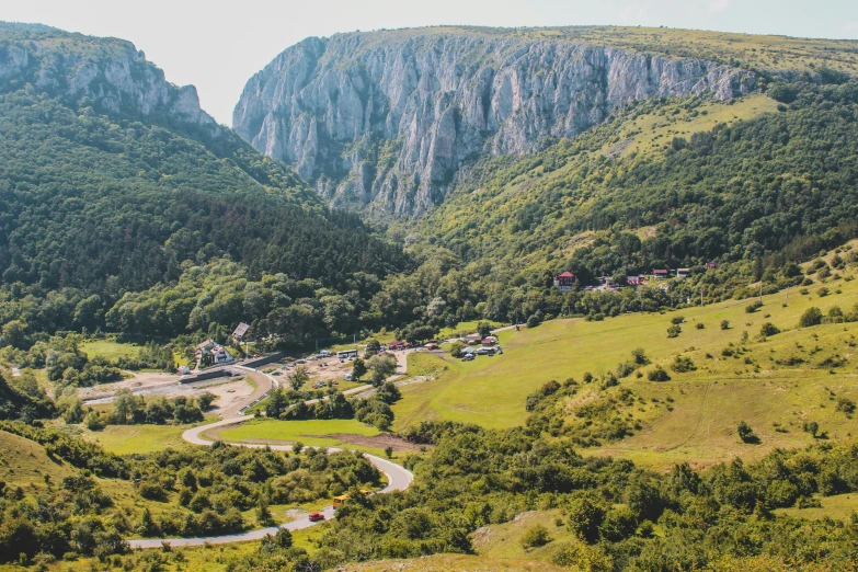 a valley with mountains in the background and lush green trees