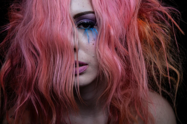 a woman with long pink hair and bright blue makeup