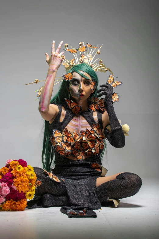 a young lady with a flower and feathers on her head sitting in the studio