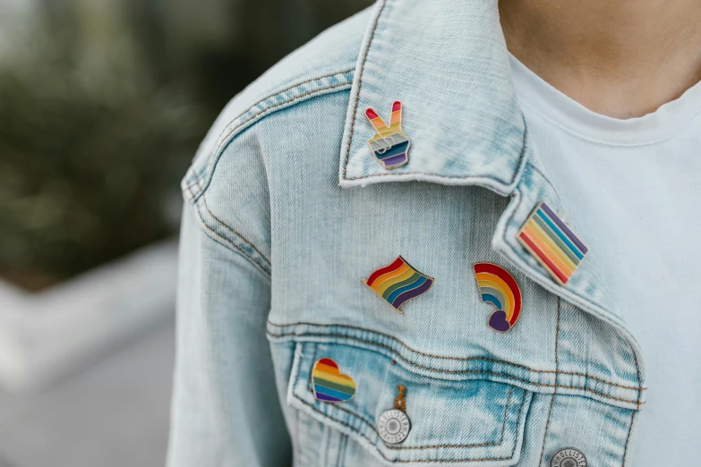 a person wears a jacket with rainbow patches on it