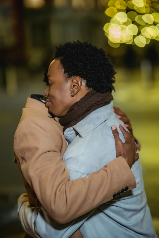 a woman hugging another woman and looking to the side