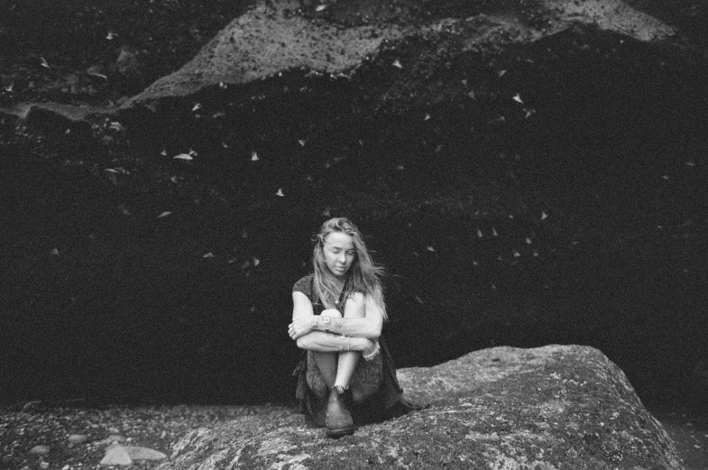 a black and white po shows a girl with her arms crossed and a mountain in the background