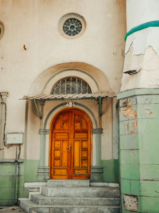 large wooden door with ornate windows on wall in old building