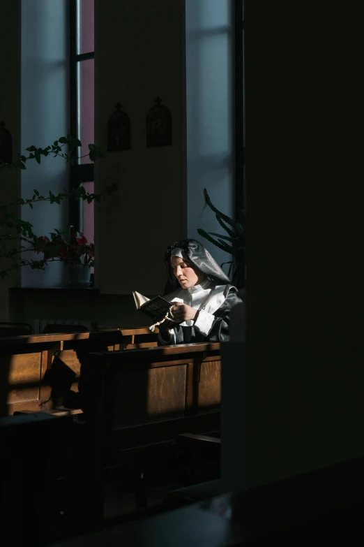 a woman in a nun outfit is sitting on the pew