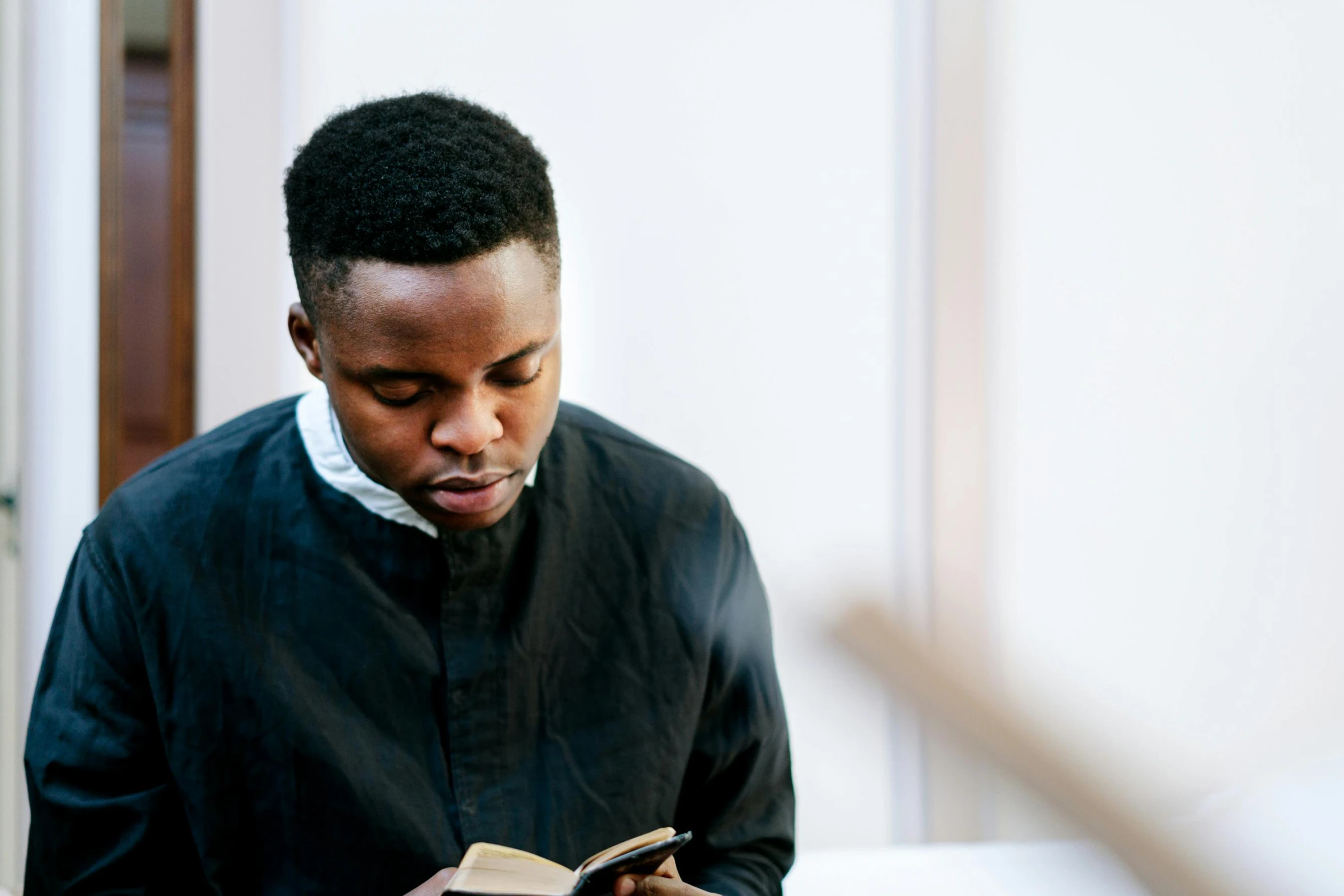 a man standing up reading a book