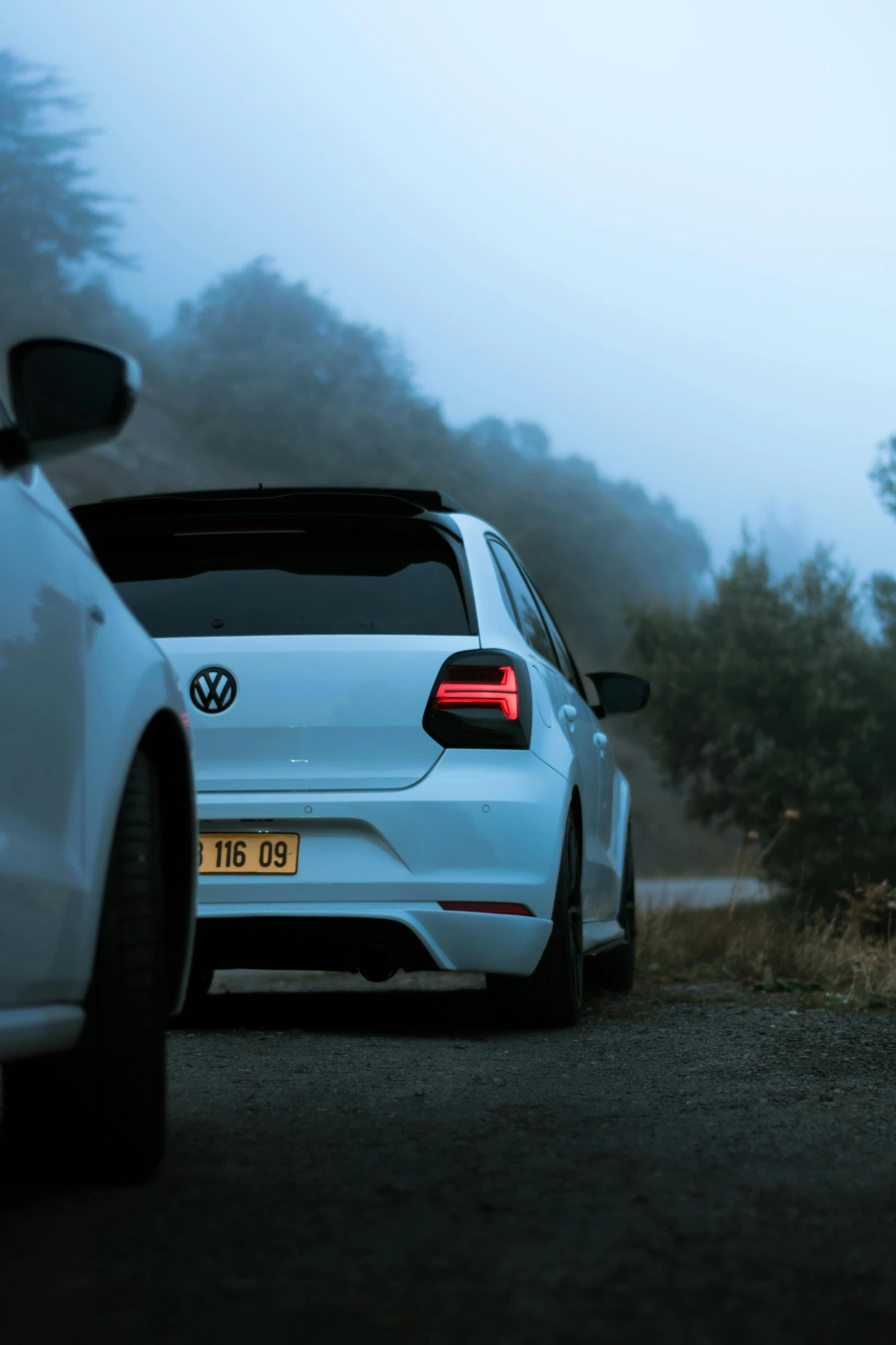 a white volkswagen car parked next to another white car