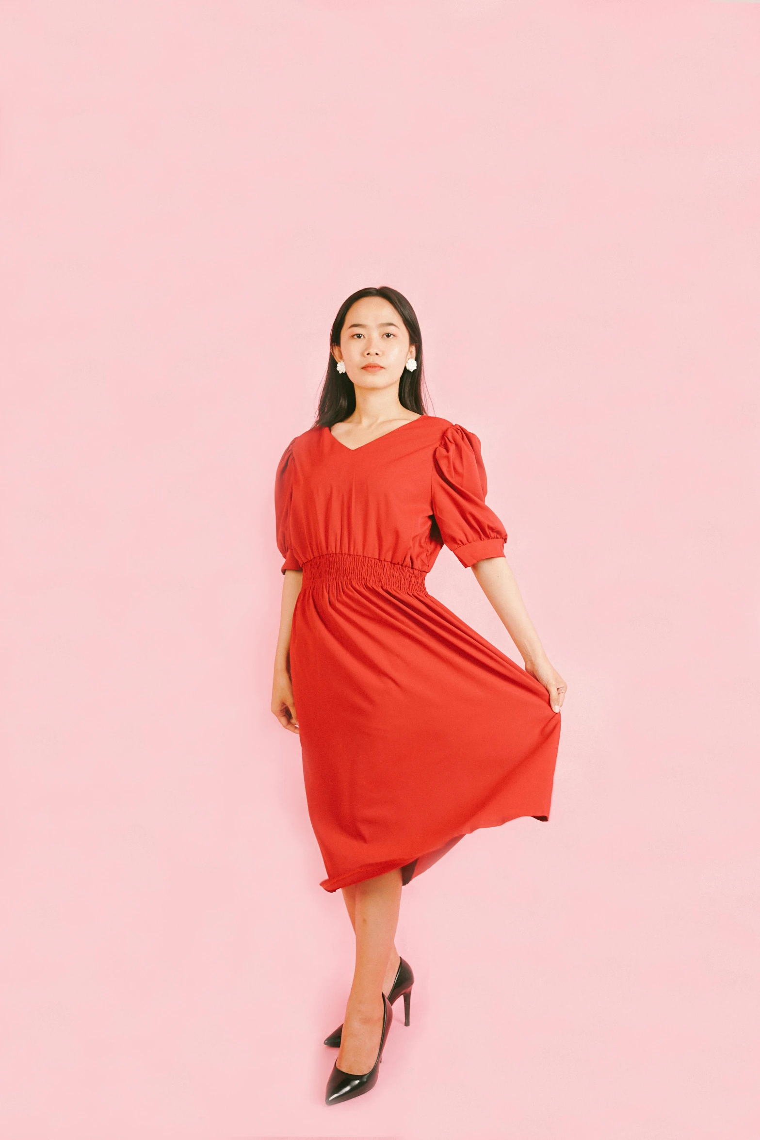 an image of a woman standing in front of a pink wall