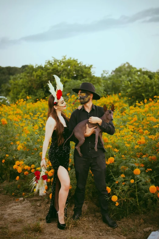 the couple dressed in costumes with their pet is posing together