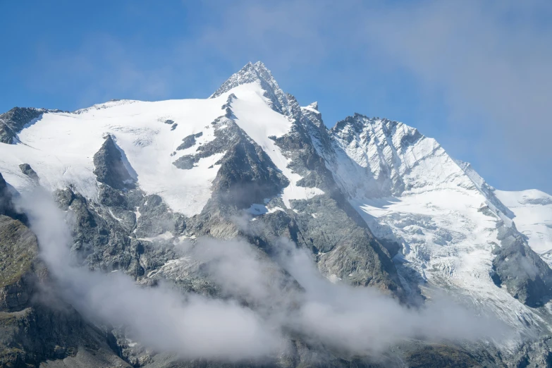 clouds moving across a mountain on a sunny day