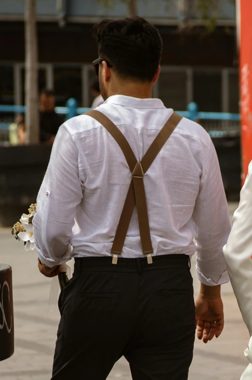 a man wearing a suspender and white shirt