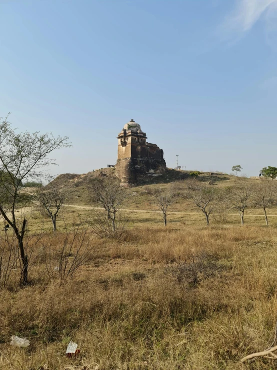 an old stone tower structure in the middle of a field