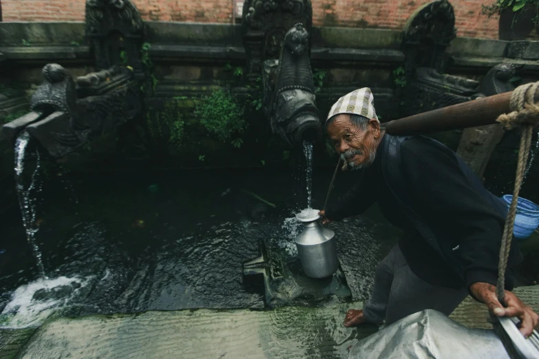 a man standing next to a stream of water