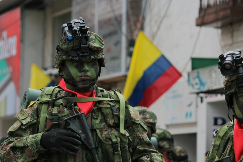 two military men with camouflage paint on their faces and one wearing a red bandanna