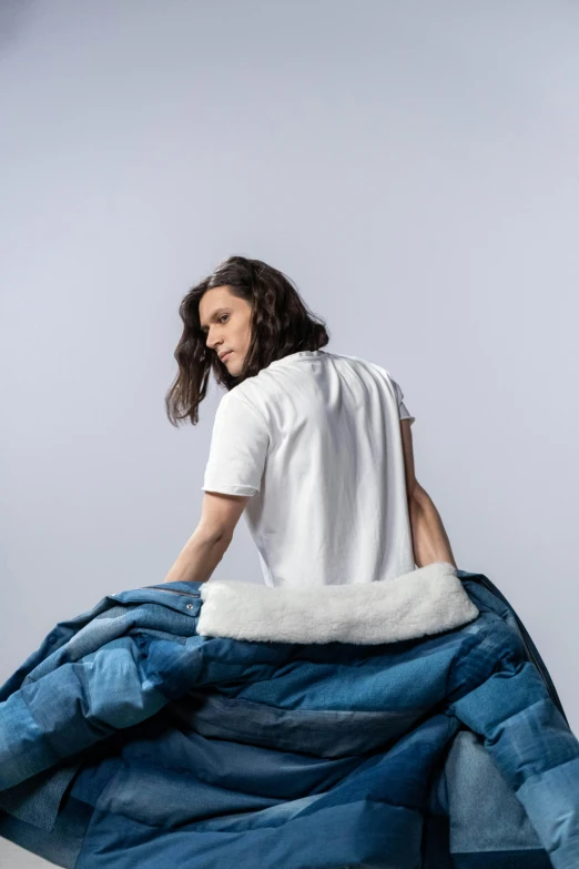 a woman in white shirt folding blue blanket