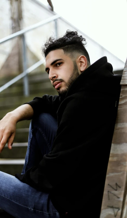 a man sits on a staircase near a building