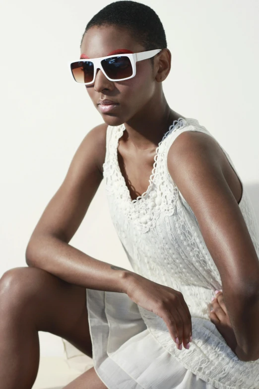 a young woman in a white dress and red glasses