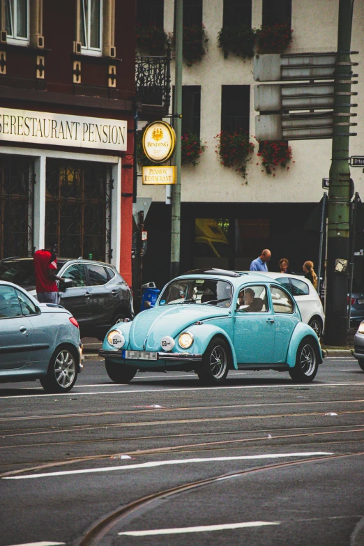 a car parked on the side of a street with people walking around