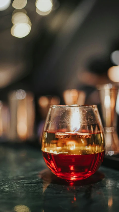 a glass that has liquid in it sitting on a counter