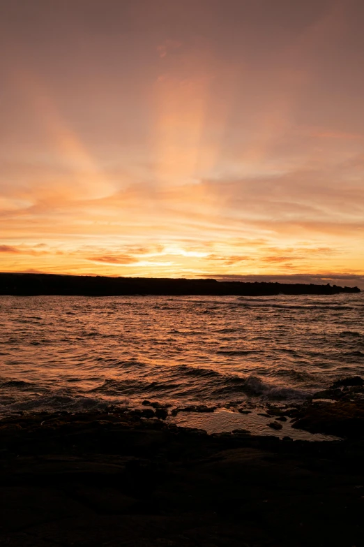 a small island off the ocean during sunset