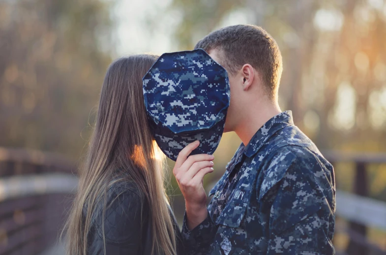 soldier covering his face and kissing a woman