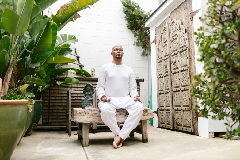 a man sitting on a bench outside of a building