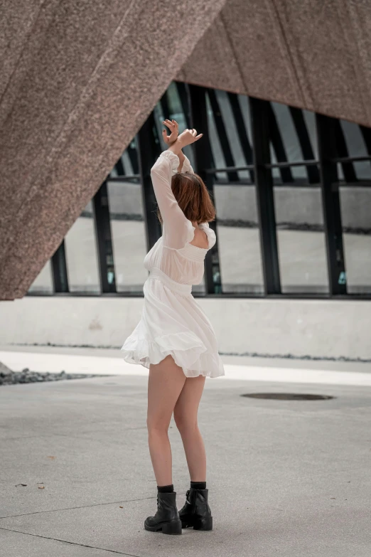 a person in white dress reaching to the sky