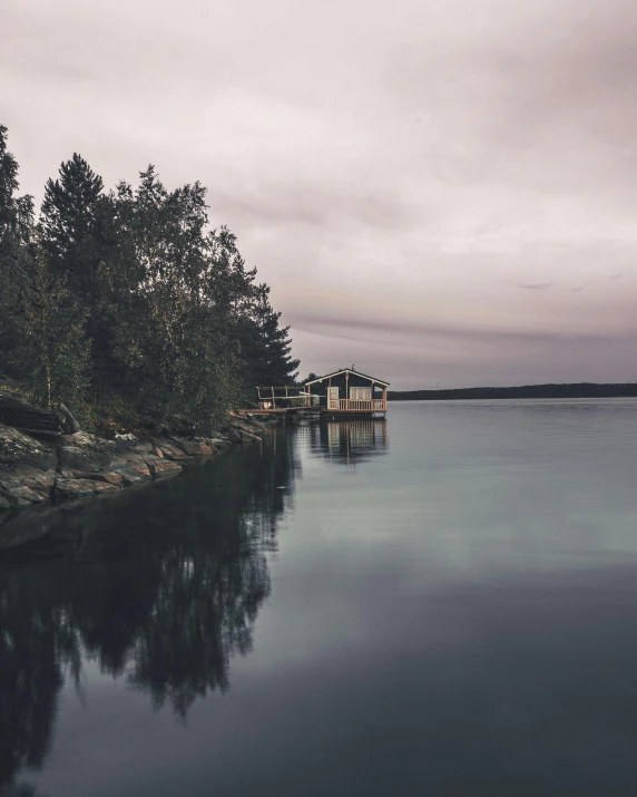 a house sits by the water on a cloudy day