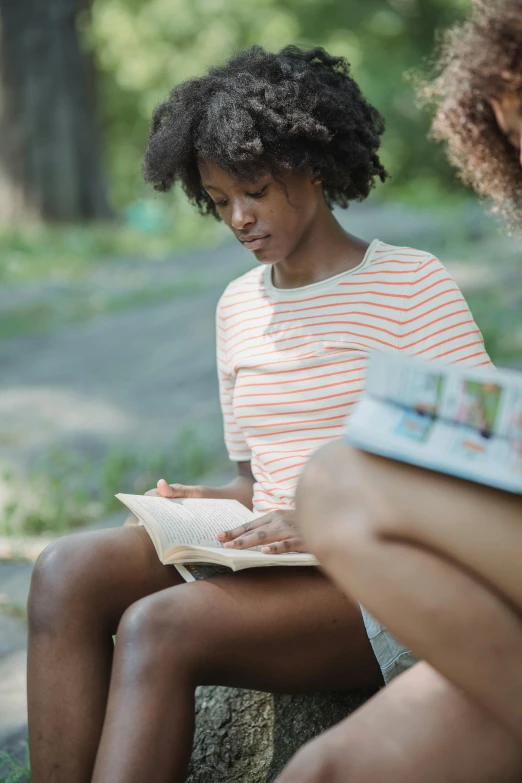 a girl is reading a book with her legs crossed