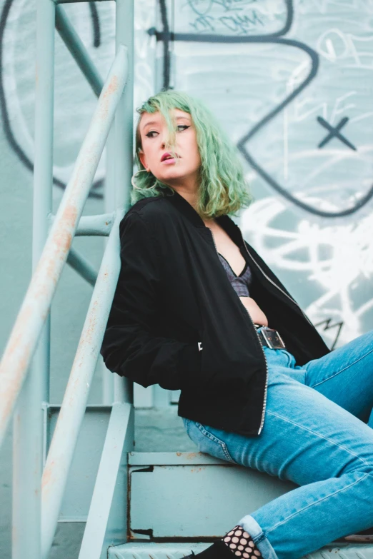 a woman with green hair is sitting on the stairs