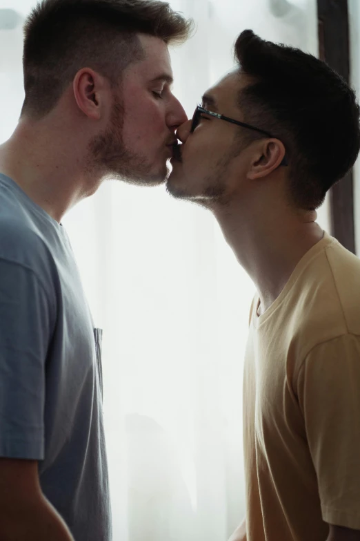 two men stand next to each other and share an awkward kiss