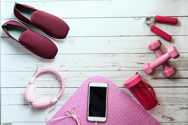 pink gym equipment laid out on top of a white table