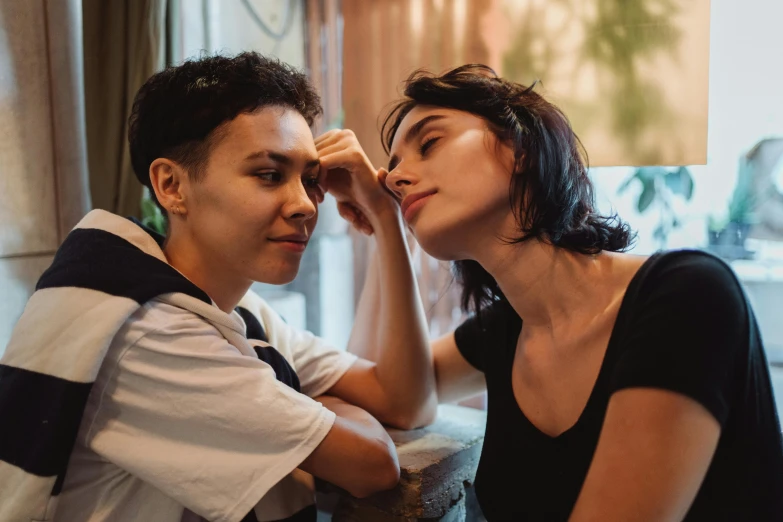 man touching the ear of woman in a bedroom