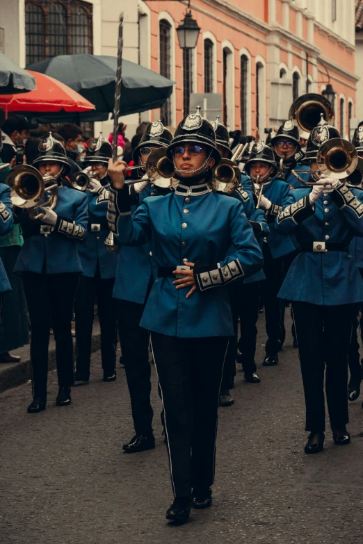 people in uniforms marching on street next to buildings