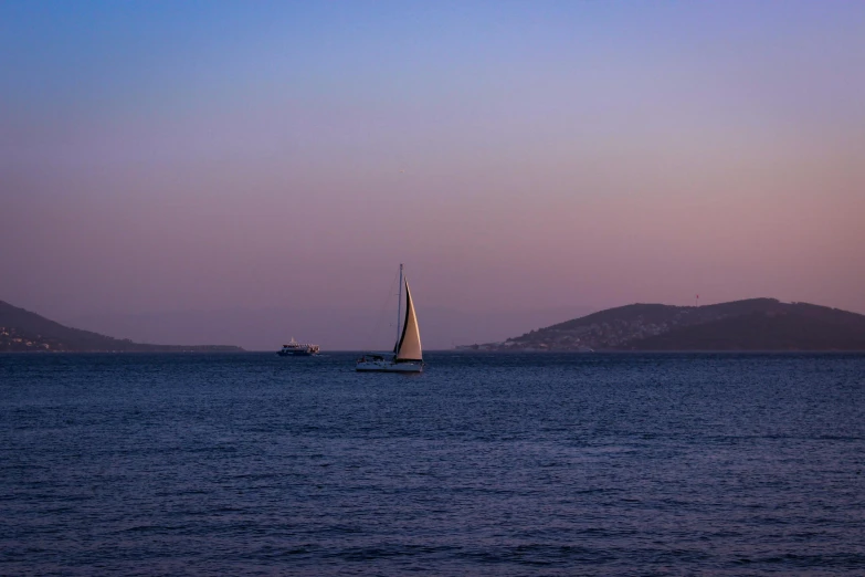 a boat sailing in the ocean at dusk