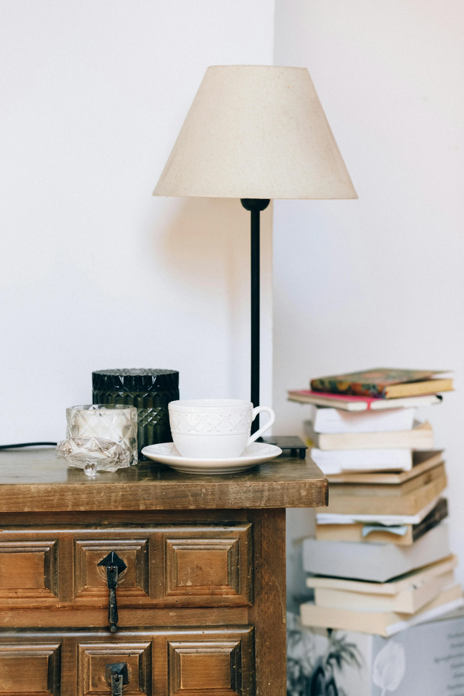 an open book sitting on a dresser next to a lamp