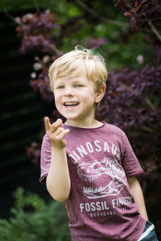 a boy poses for a po while making the v sign