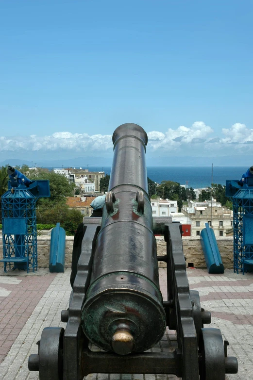 a large cannon sits on top of a cobblestone walkway