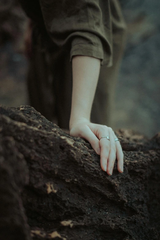 person leaning on rock with their hands on the rocks