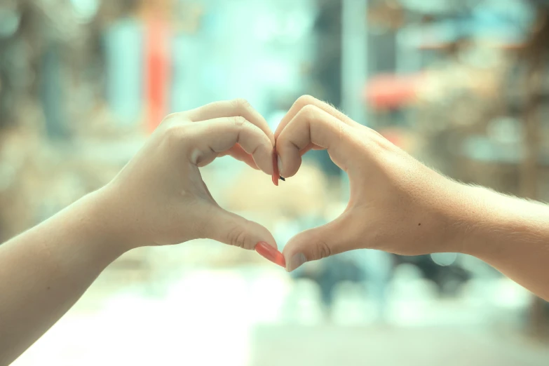 two hands making a heart shape with their fingers